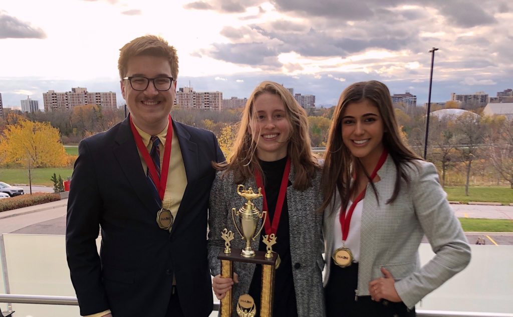 Three students posing for picture holding 2nd place trophy