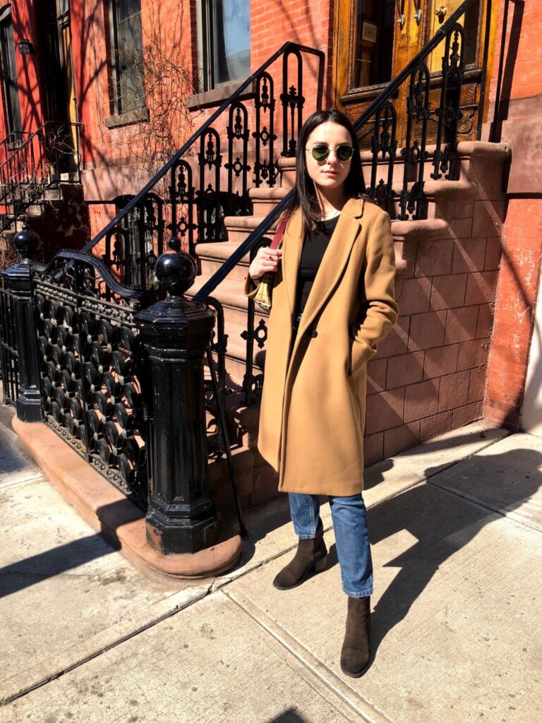 Student standing in front of stairs on New York street