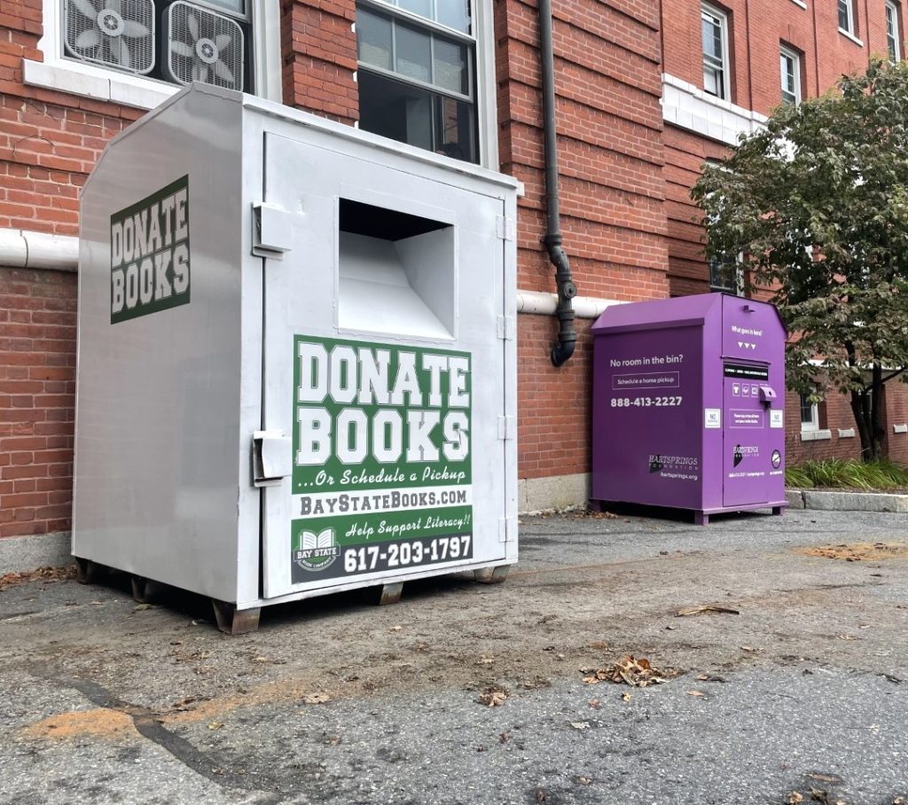 book collection bin in front of brick wall